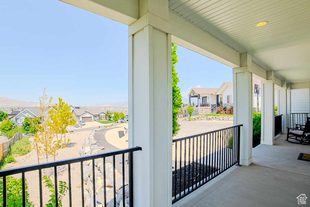 Covered porch featuring a residential view