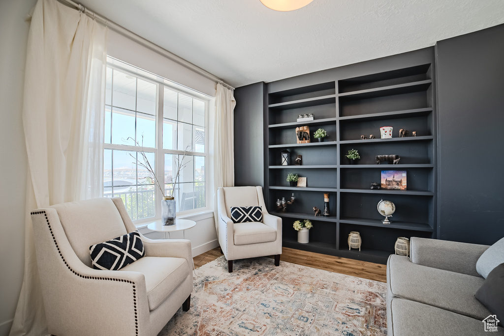 Sitting room featuring wood finished floors and built in shelves