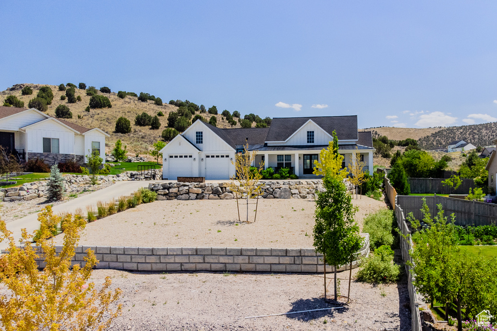 View of front of home with driveway, an attached garage, and board and batten siding
