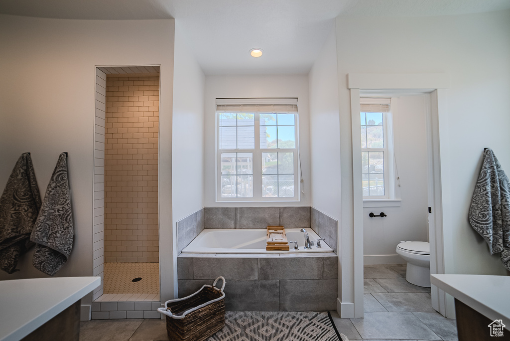 Bathroom featuring vanity, a garden tub, a tile shower, and tile patterned floors
