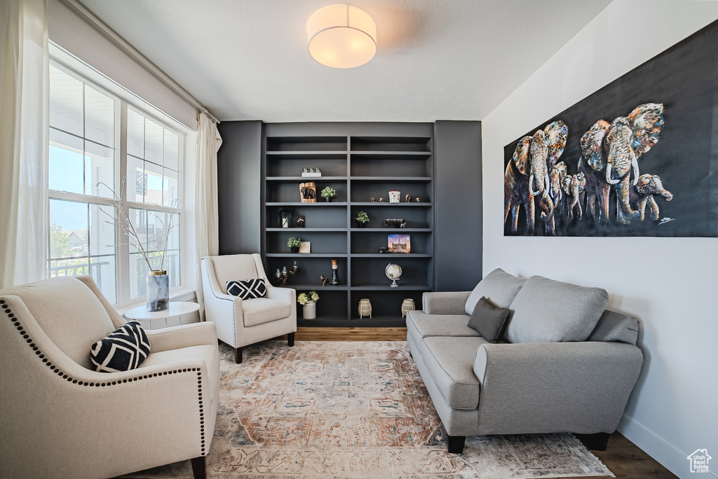 Sitting room featuring wood finished floors and built in features