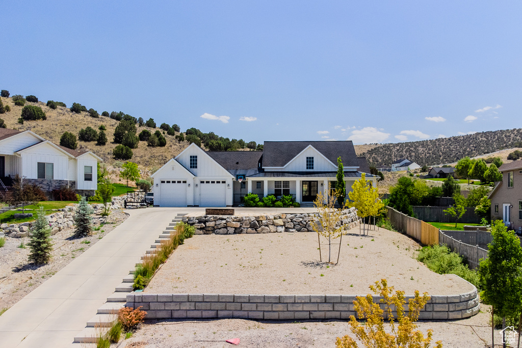 View of front of house featuring a garage, a residential view, and driveway