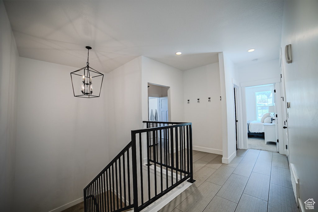 Hallway with an upstairs landing, a chandelier, and recessed lighting
