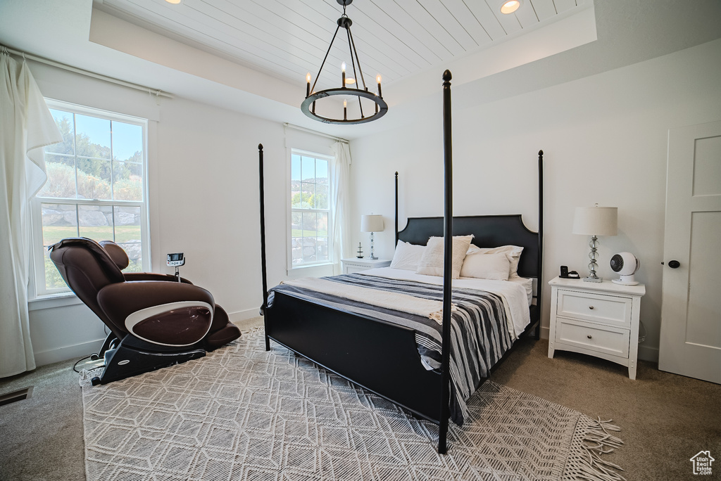Carpeted bedroom featuring a tray ceiling, wood ceiling, a chandelier, and recessed lighting