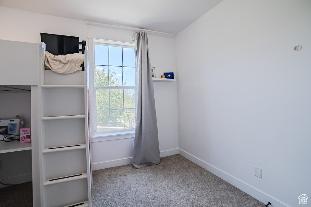 Unfurnished bedroom featuring multiple windows and carpet