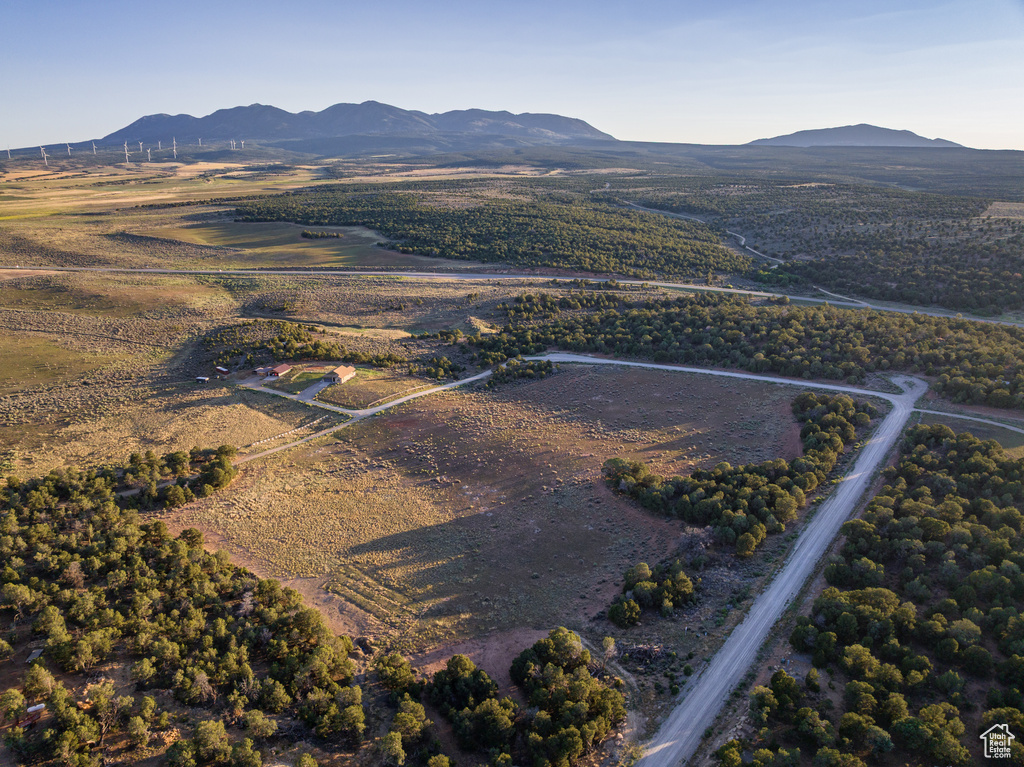 Aerial view of property and surrounding area featuring a mountain backdrop and rural landscape