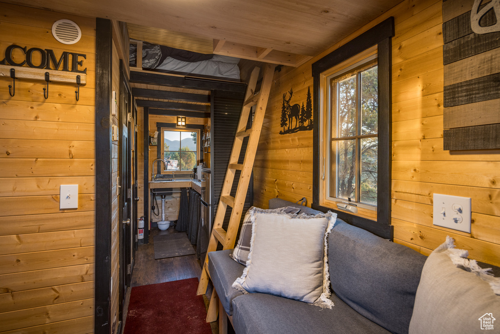 Interior space with wood walls, dark wood-style flooring, and wood ceiling