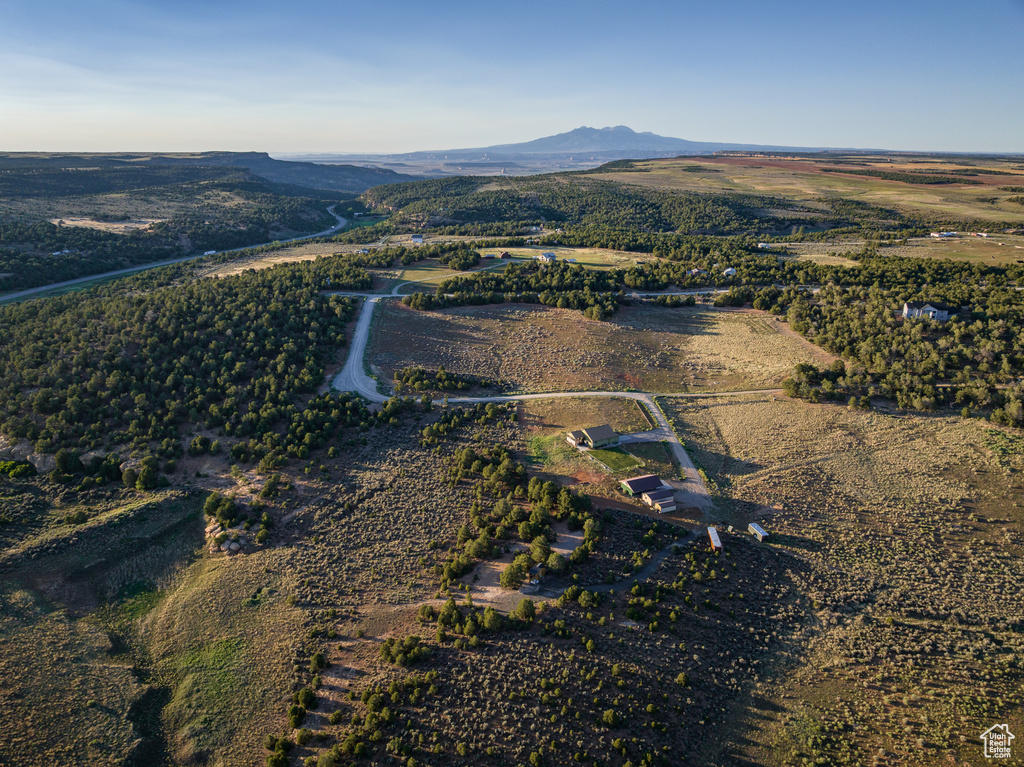 Aerial view of property and surrounding area featuring a mountainous background