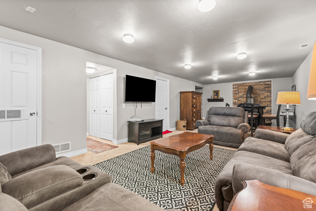 Carpeted living area featuring a wood stove and baseboards