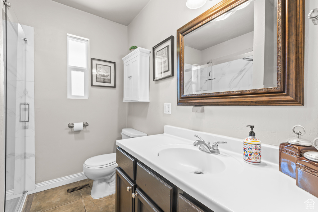 Bathroom featuring a marble finish shower, vanity, and tile patterned flooring