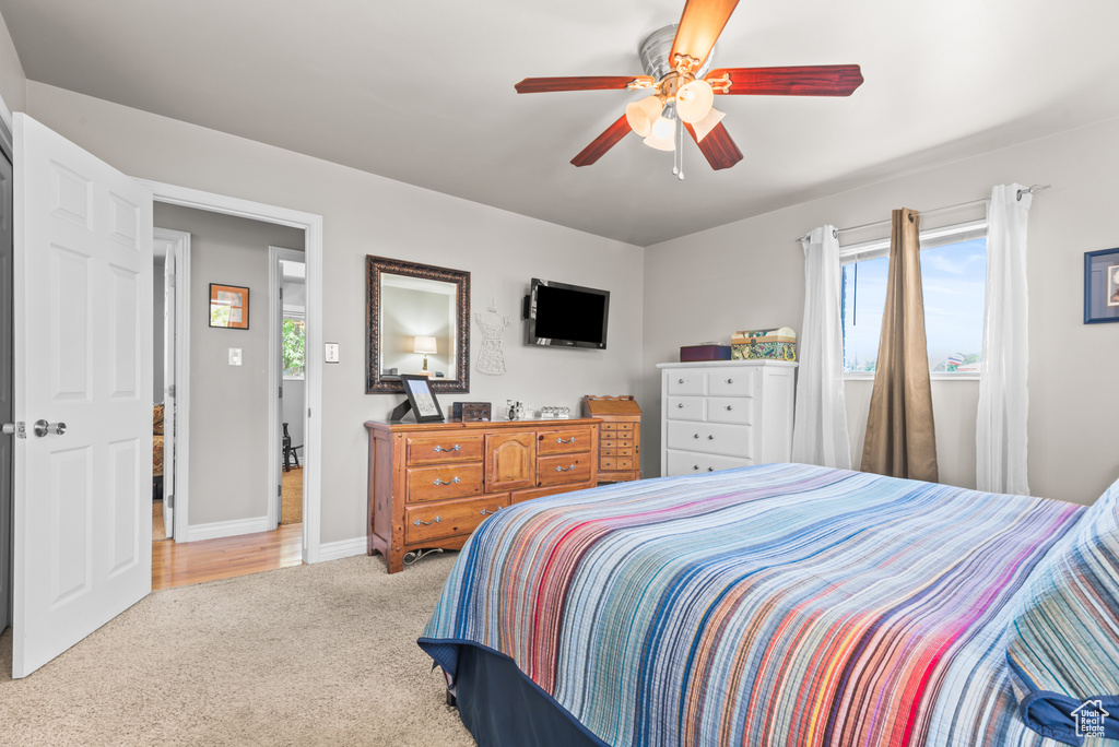 Carpeted bedroom featuring multiple windows and a ceiling fan