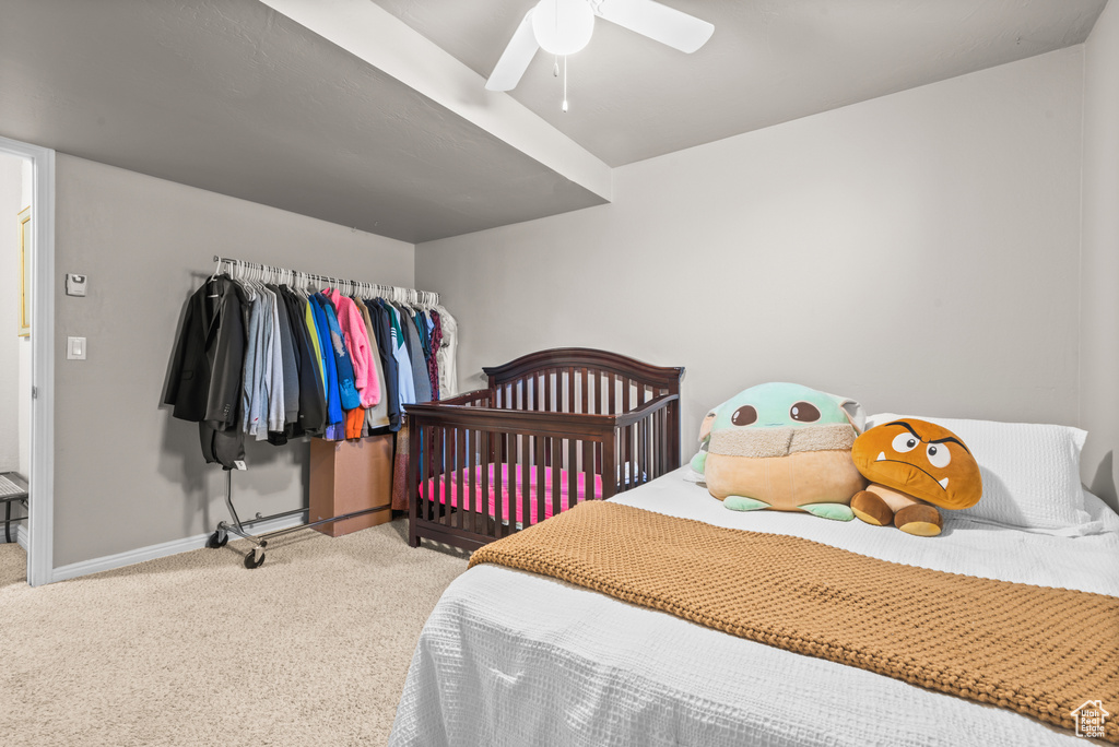 Carpeted bedroom featuring baseboards and ceiling fan