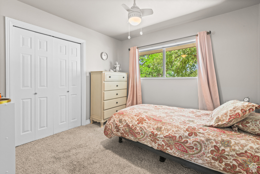 Carpeted bedroom featuring a closet and a ceiling fan