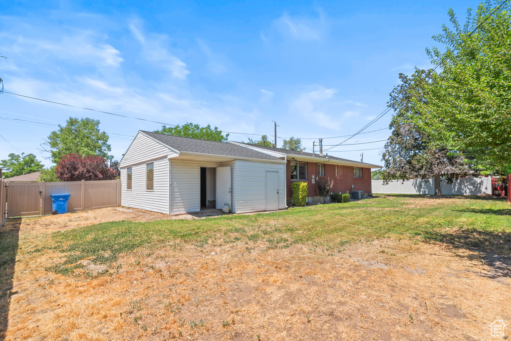 Rear view of property with a fenced backyard and a gate