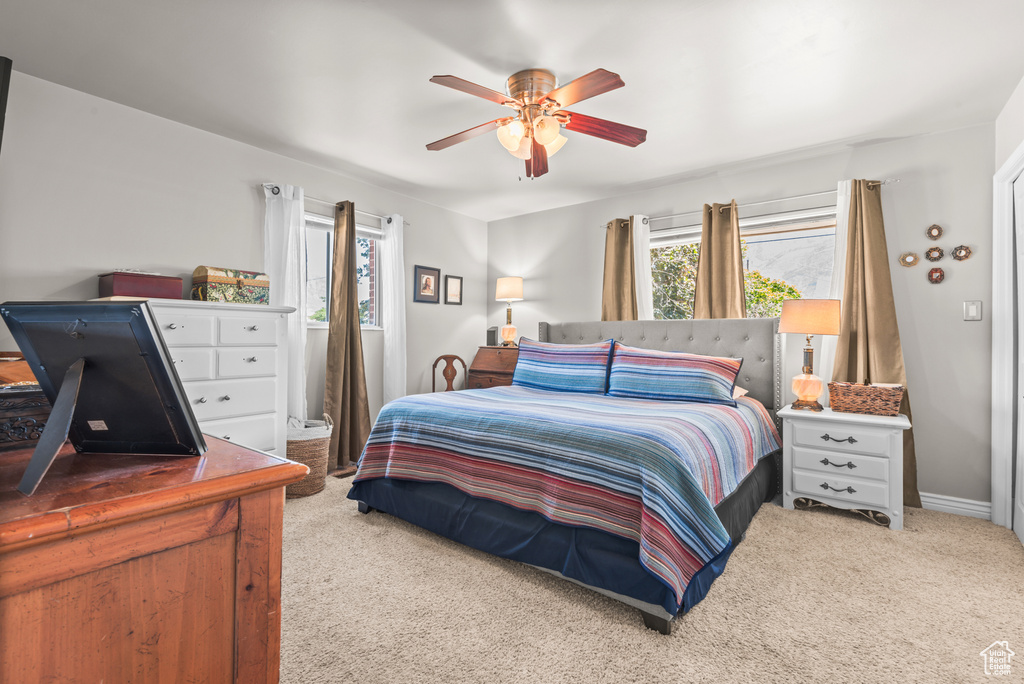 Carpeted bedroom with a ceiling fan