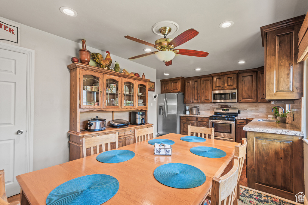 Kitchen with stainless steel appliances, a ceiling fan, light countertops, recessed lighting, and decorative backsplash