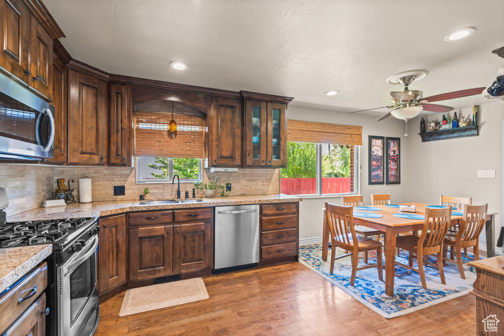 Kitchen with stainless steel appliances, plenty of natural light, light wood finished floors, and recessed lighting