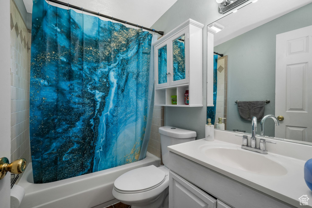 Bathroom featuring shower / tub combo with curtain and vanity