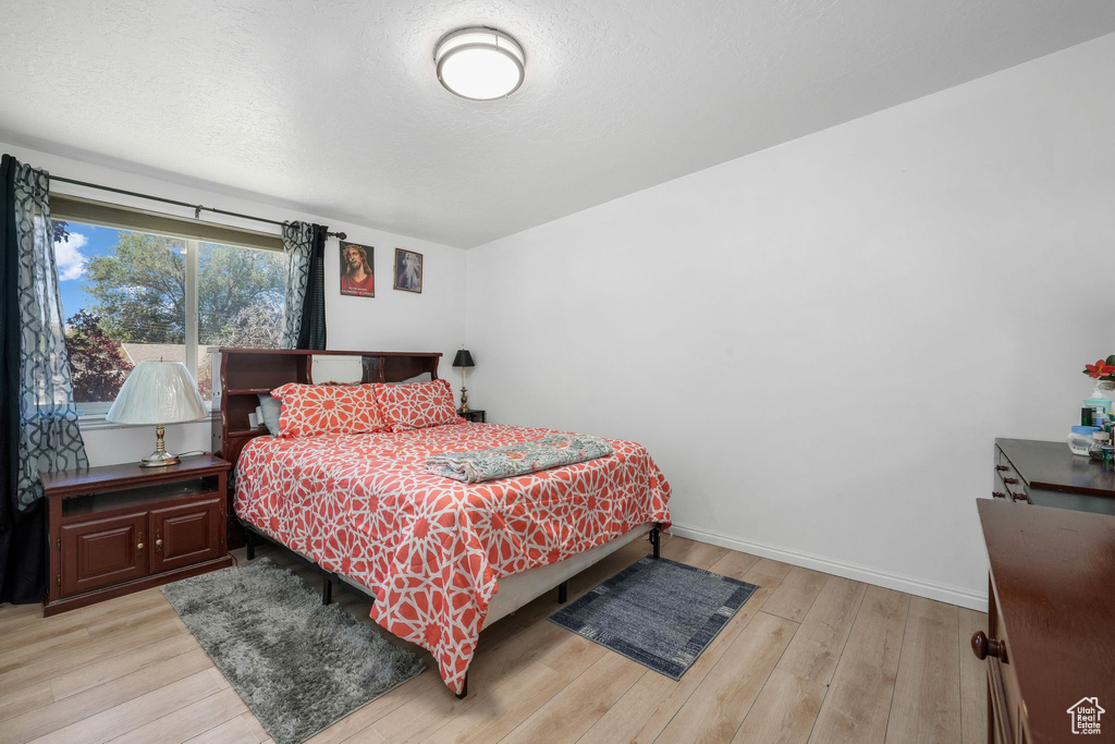 Bedroom with light wood-style floors and baseboards
