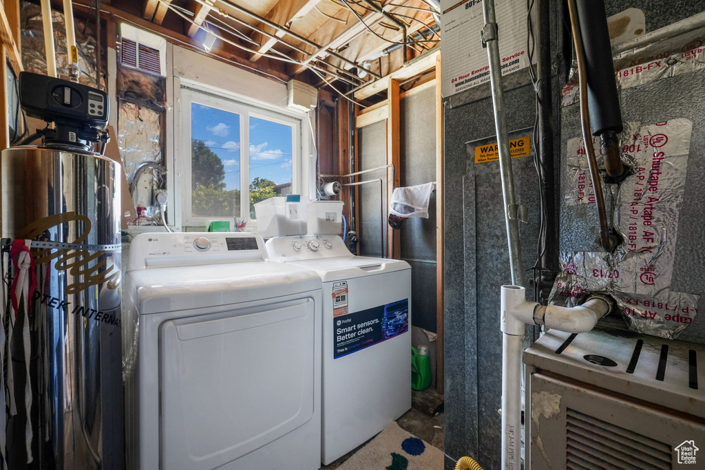 Laundry room featuring washing machine and dryer and heating unit