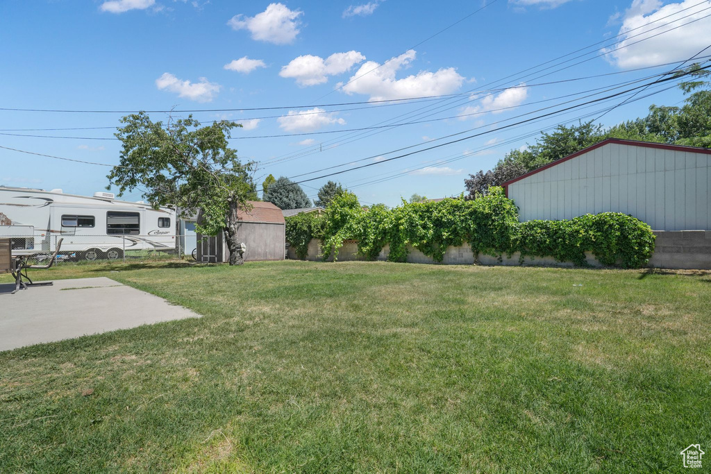 View of grassy yard with a patio