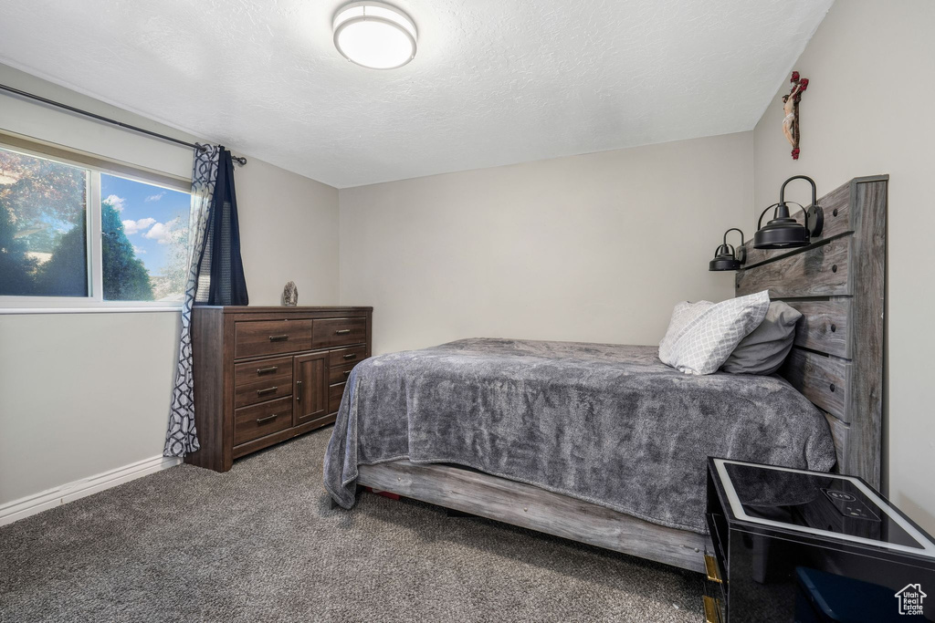 Bedroom featuring carpet and baseboards