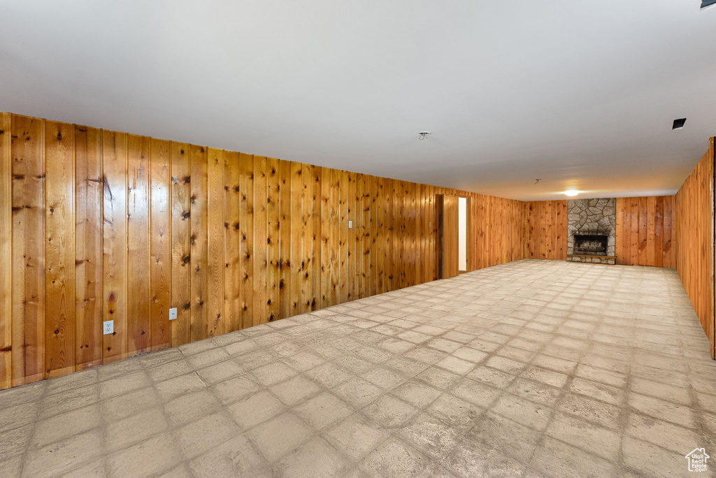 Finished basement featuring wood walls and a stone fireplace