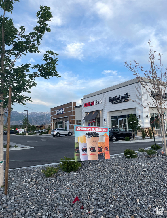 View of commercial property featuring uncovered parking and a mountain view