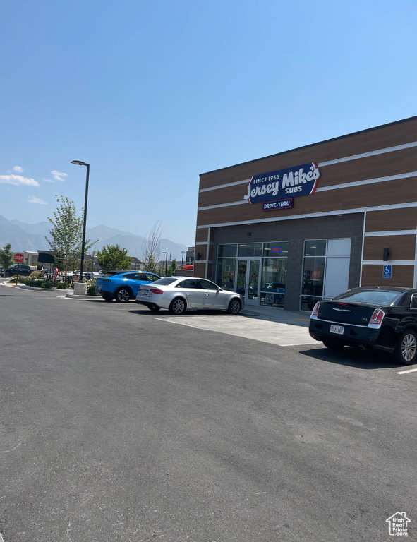 View of building exterior featuring a mountain view and uncovered parking