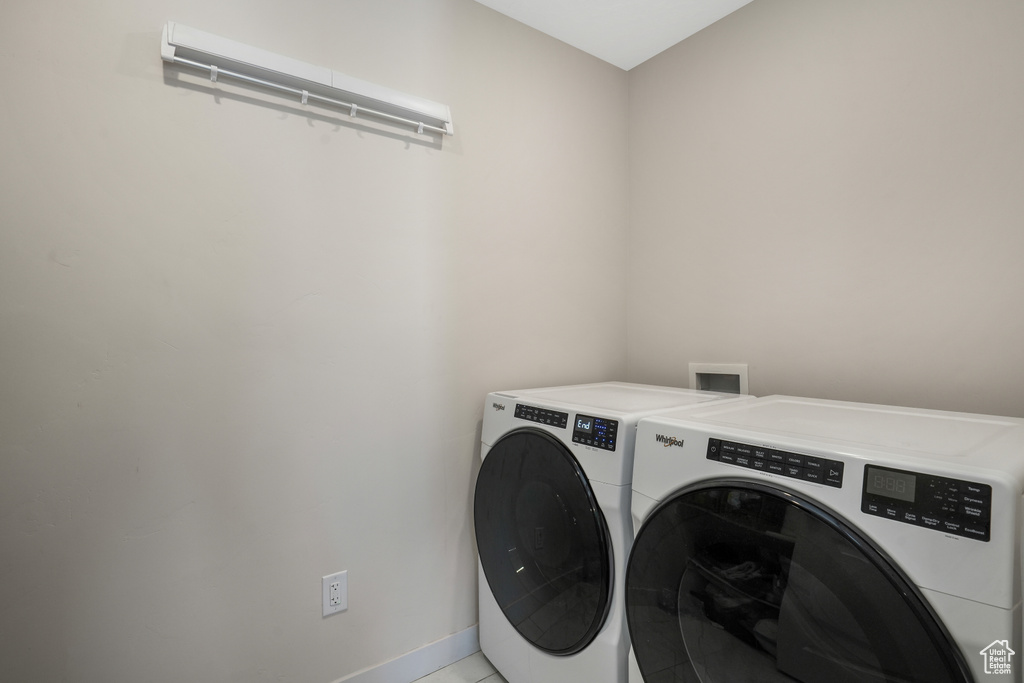 Washroom featuring washing machine and dryer and baseboards