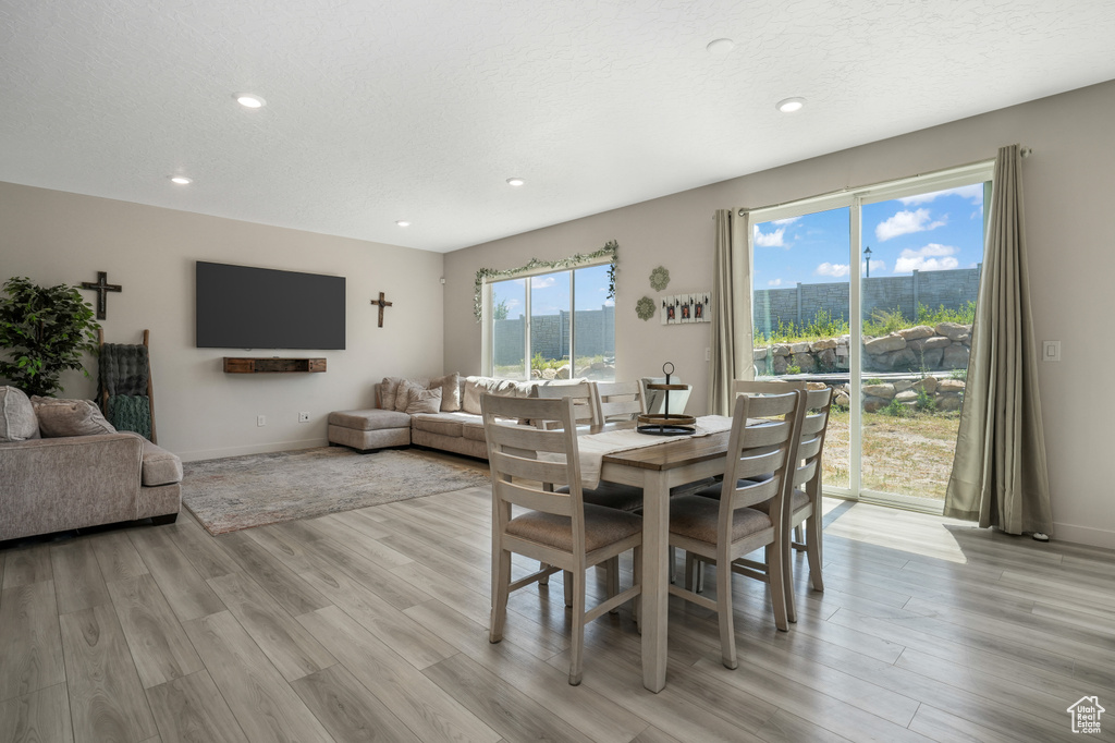 Dining room with light wood-style flooring and recessed lighting