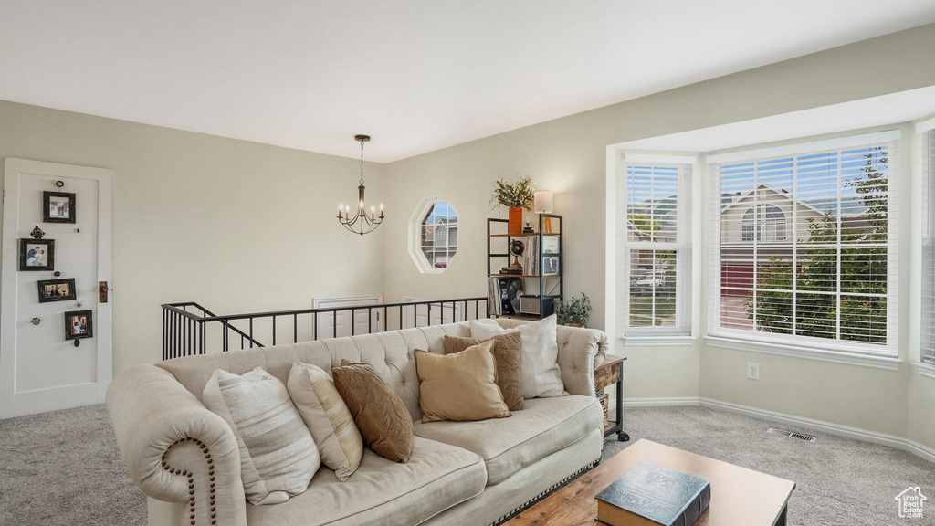 Living area with light carpet and a chandelier