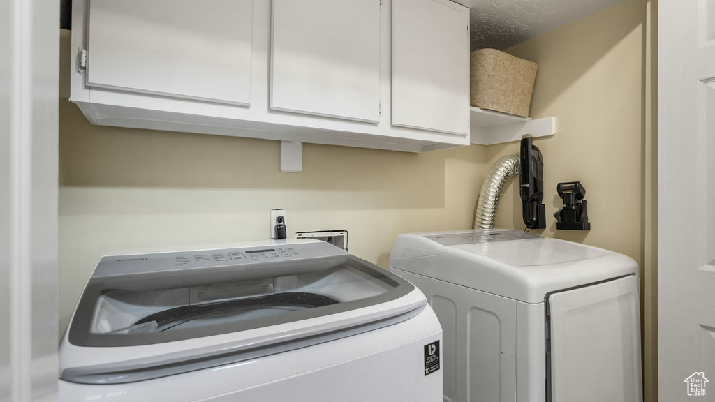 Laundry room with washer and clothes dryer and cabinet space