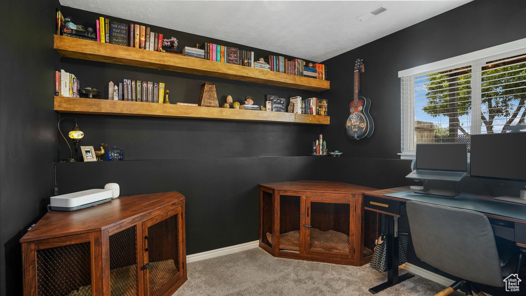 Carpeted home office featuring baseboards