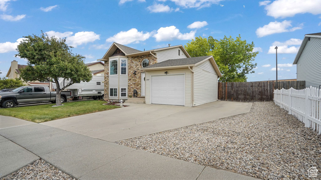 View of front of house featuring driveway, a garage, roof with shingles, and brick siding