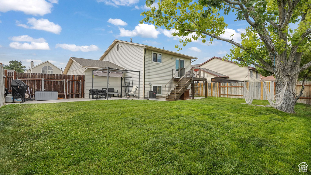 Back of property featuring a fenced backyard, a patio area, and stairway