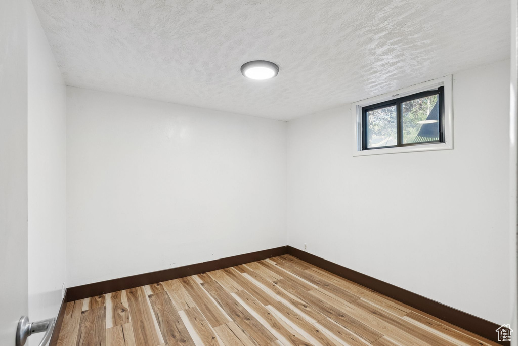 Empty room with a textured ceiling and wood finished floors
