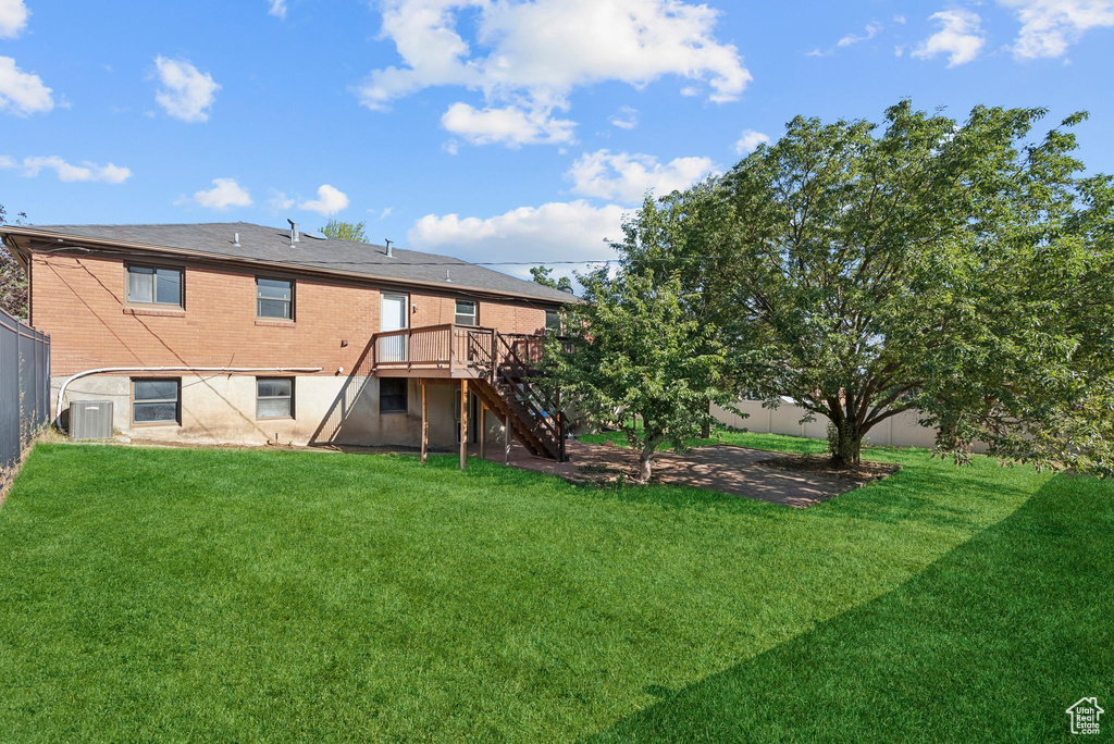 Rear view of property with stairs, a fenced backyard, a wooden deck, and brick siding