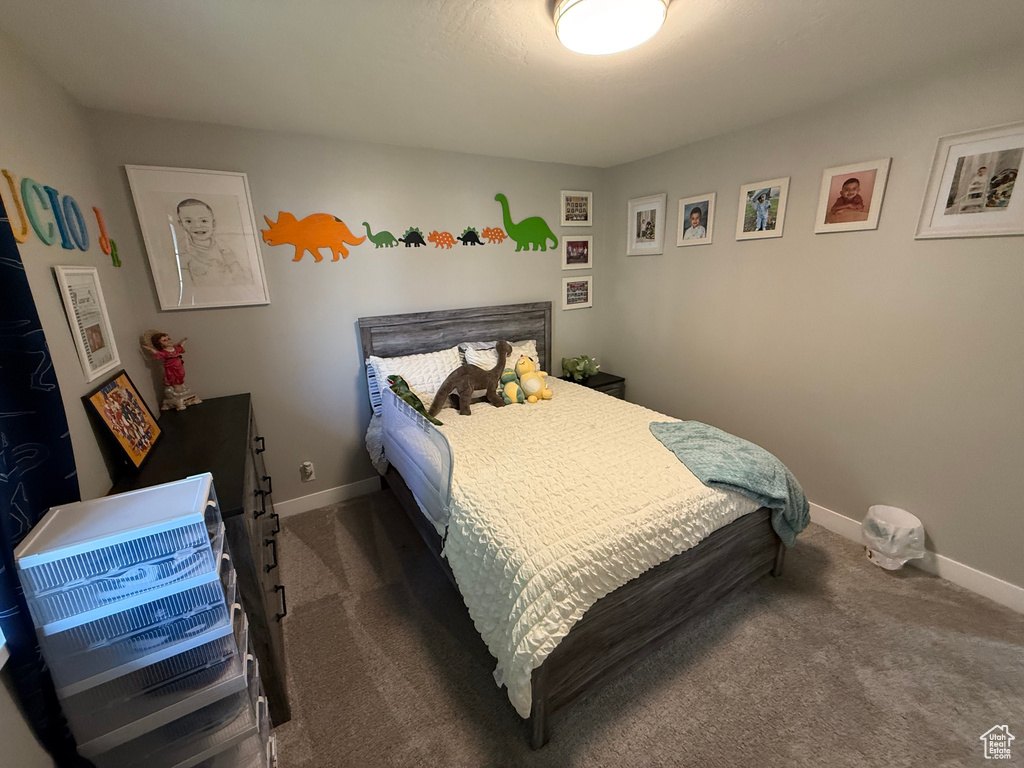Bedroom featuring dark carpet and baseboards