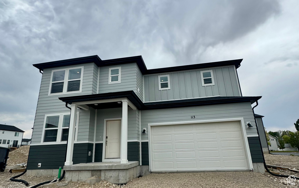 View of front of house with an attached garage and driveway