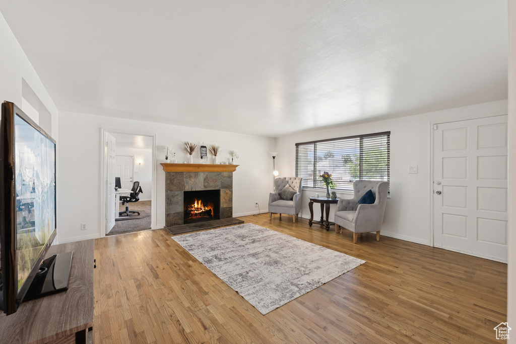 Living area with a tile fireplace and wood finished floors