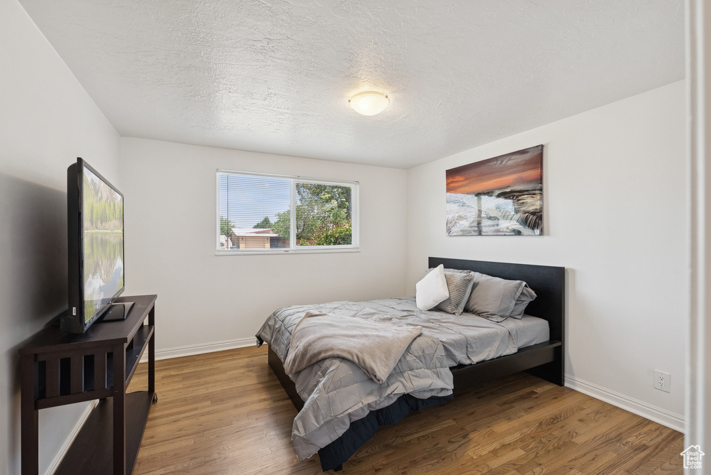 Bedroom featuring wood finished floors and a textured ceiling