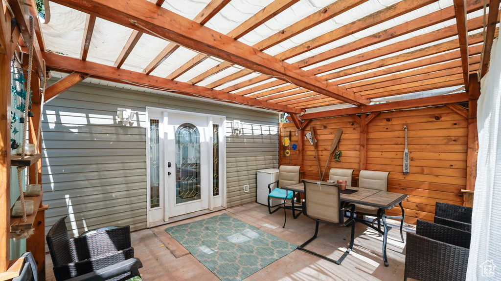 Wooden terrace with outdoor dining area, a pergola, and a patio