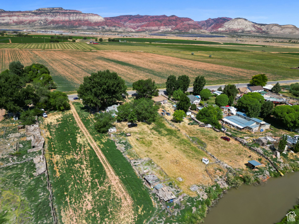 Aerial overview of property\\\'s location featuring rural landscape, large plots for crops, and a mountain backdrop