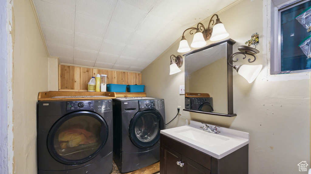 Laundry area with washer and clothes dryer and wood walls