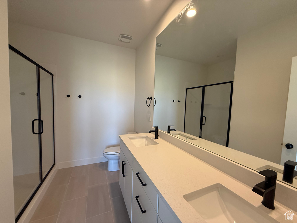Full bath featuring a shower stall, double vanity, and tile patterned floors