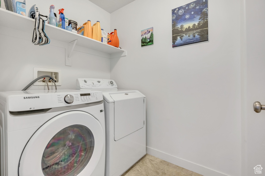 Laundry area featuring separate washer and dryer and light tile patterned floors