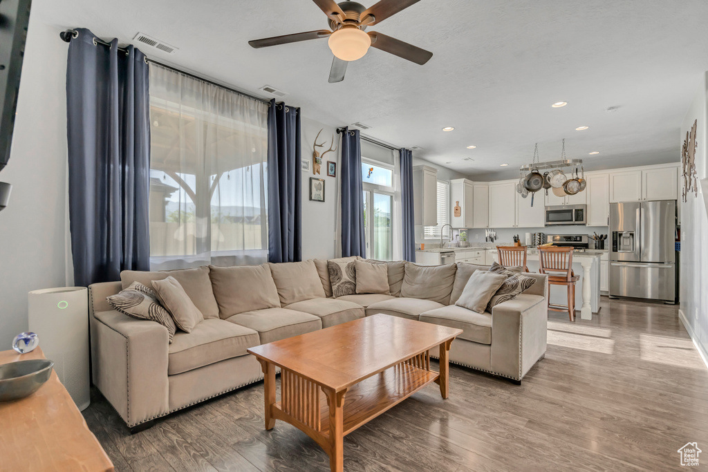 Living room featuring ceiling fan, light wood finished floors, and recessed lighting