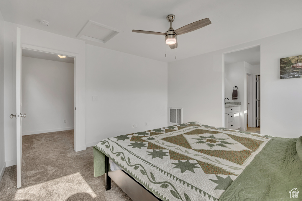 Carpeted bedroom featuring attic access and ceiling fan