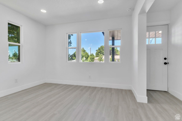 Entrance foyer with light wood-style floors and recessed lighting
